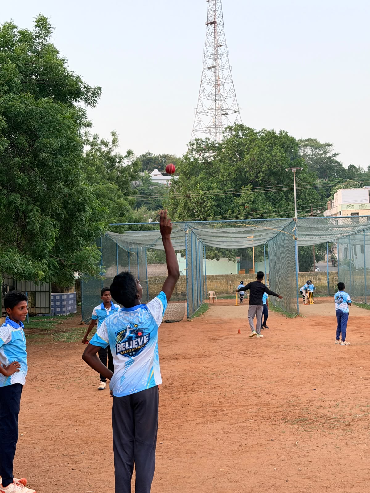 A young player bowling during practice at the academy nets