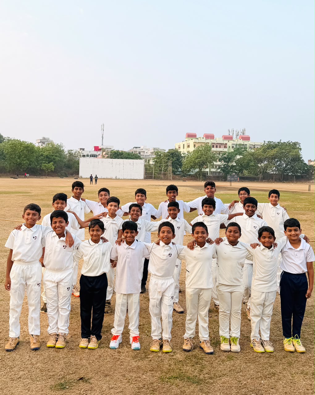 Believe Cricket Academy players in white cricket kits on the field