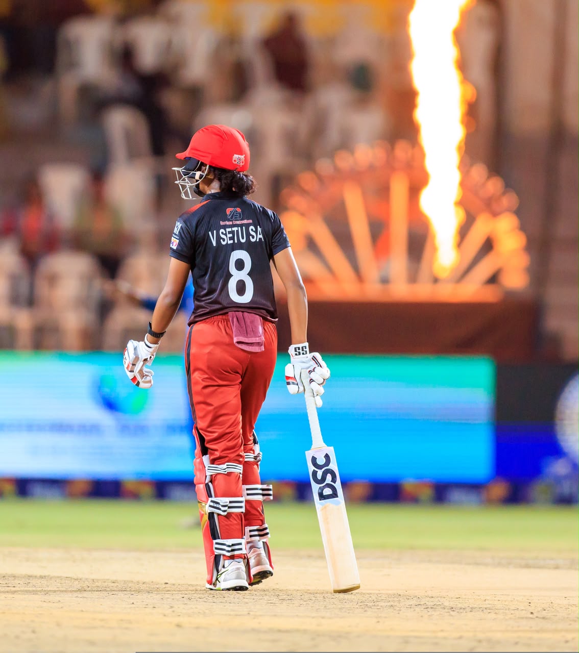 Setu Sai walking onto the cricket field with a bat