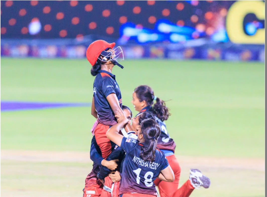 Women's cricket team celebrating together on the field